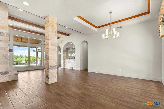1607 Filtro, New Braunfels, TX 78132 - unfurnished living room featuring arched walkways, a chandelier, recessed lighting, dark wood-type flooring, and ornate columns