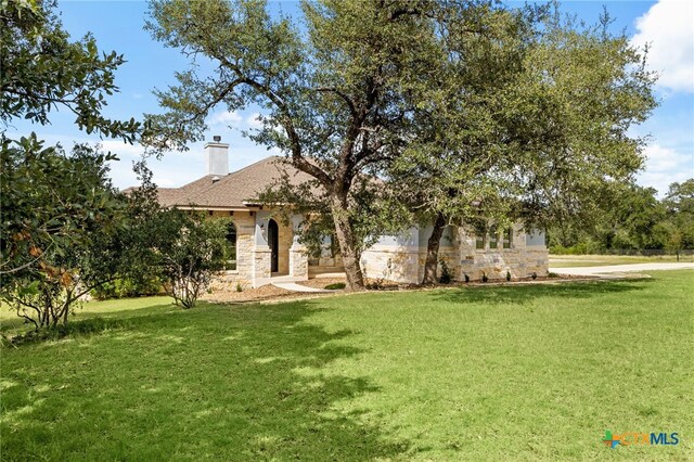 1607 Filtro, New Braunfels, TX 78132 - view of front facade featuring stone siding, a front yard, and a chimney