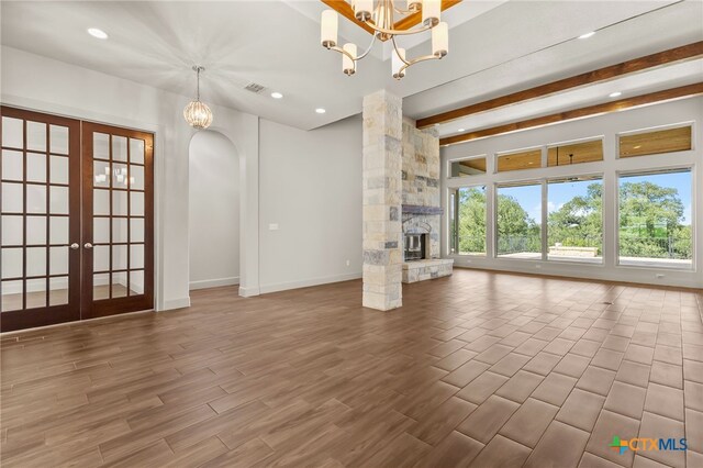 1607 Filtro, New Braunfels, TX 78132 - unfurnished living room featuring a chandelier, french doors, wood finished floors, recessed lighting, and beam ceiling