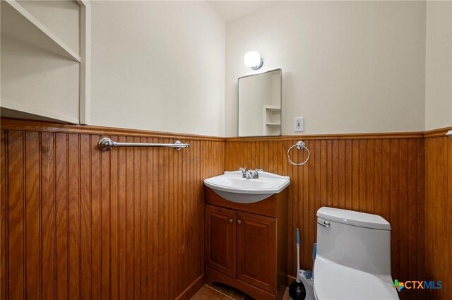 201 Hillcrest Dr, Luling, TX 78648 - half bath with a wainscoted wall, vanity, and toilet