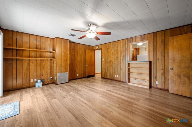 201 Hillcrest Dr, Luling, TX 78648 - unfurnished bedroom featuring wooden walls, wood finished floors, baseboards, and a ceiling fan