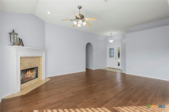 unfurnished living room with dark hardwood / wood-style flooring, a fireplace, ceiling fan, and vaulted ceiling