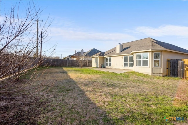 rear view of house featuring a lawn and a patio area