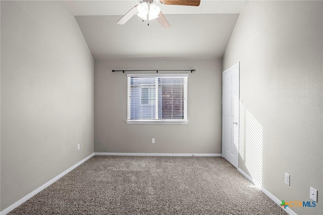 carpeted spare room featuring ceiling fan and vaulted ceiling