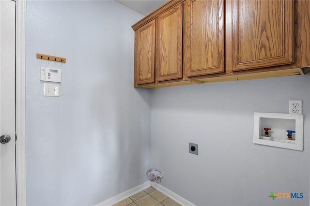 clothes washing area with cabinets, light tile patterned floors, hookup for a washing machine, and electric dryer hookup