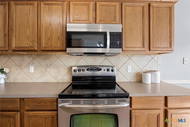 kitchen with appliances with stainless steel finishes and backsplash