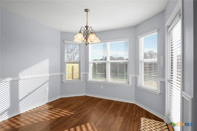 unfurnished dining area with wood-type flooring and a chandelier