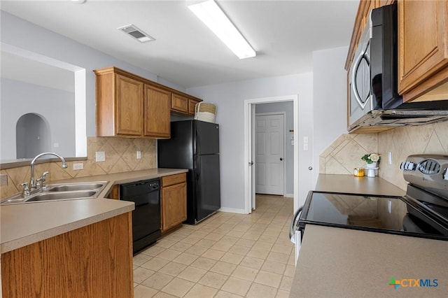 kitchen featuring light tile patterned flooring, sink, tasteful backsplash, and black appliances