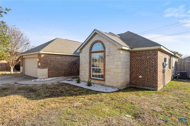 view of front of property with a garage, a front yard, and central AC unit