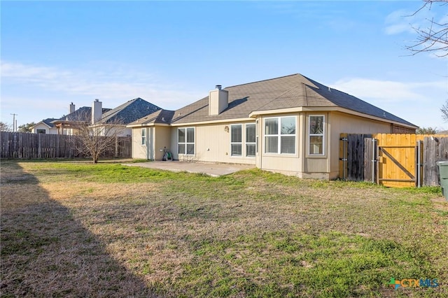 back of house with a yard and a patio area