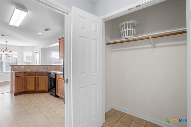 kitchen with sink, light tile patterned floors, black dishwasher, kitchen peninsula, and pendant lighting