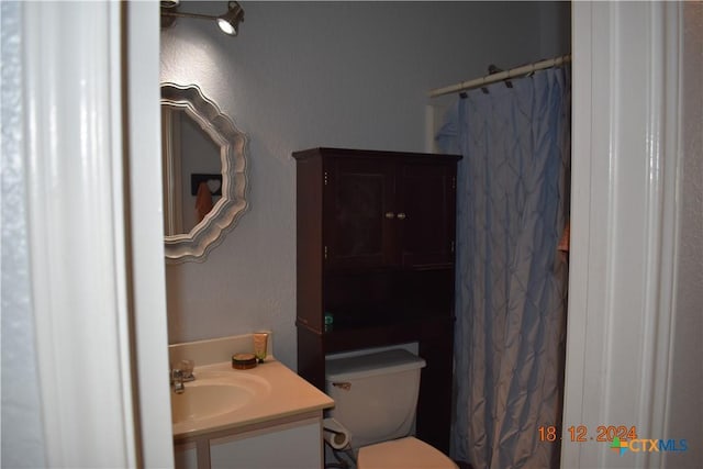 bathroom with vanity, toilet, and curtained shower