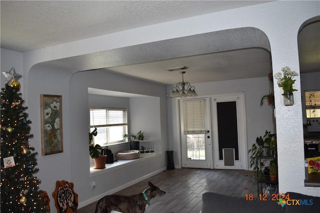 interior space featuring a chandelier, a textured ceiling, and hardwood / wood-style flooring