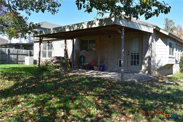 back of property with a yard and a patio