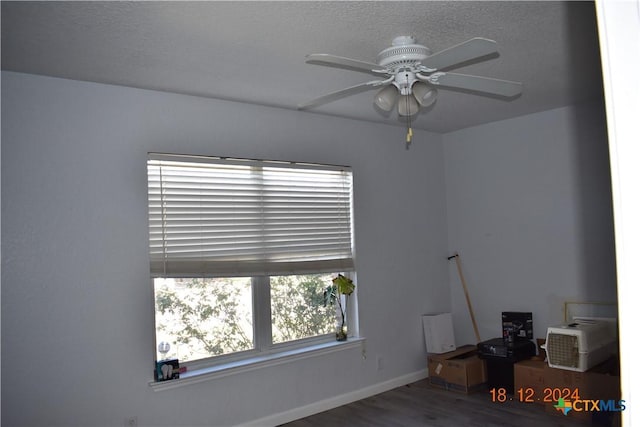 empty room with hardwood / wood-style flooring, ceiling fan, and a textured ceiling