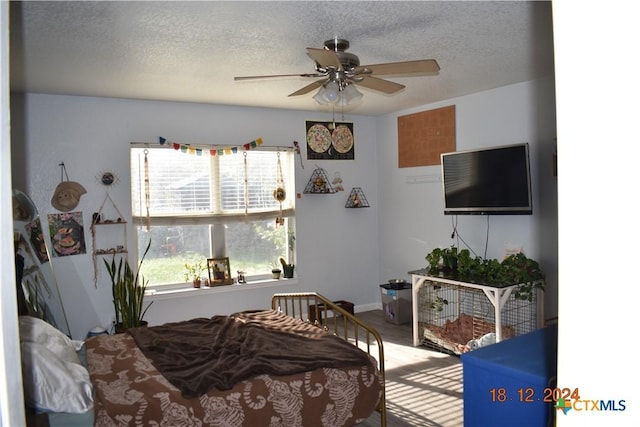 bedroom featuring ceiling fan and a textured ceiling