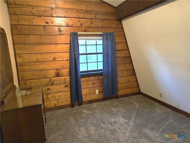 bonus room with a textured ceiling, wood walls, vaulted ceiling, and dark colored carpet