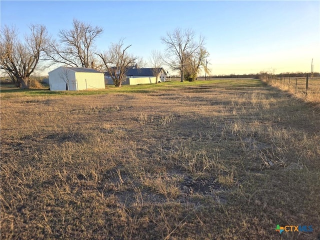 yard at dusk with a rural view