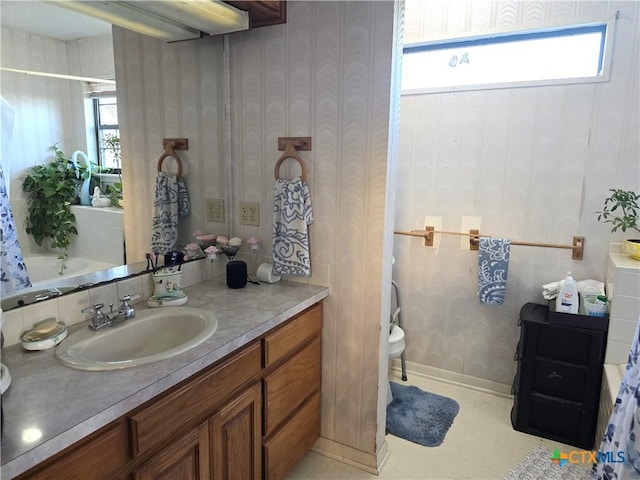 bathroom with vanity, a healthy amount of sunlight, and toilet