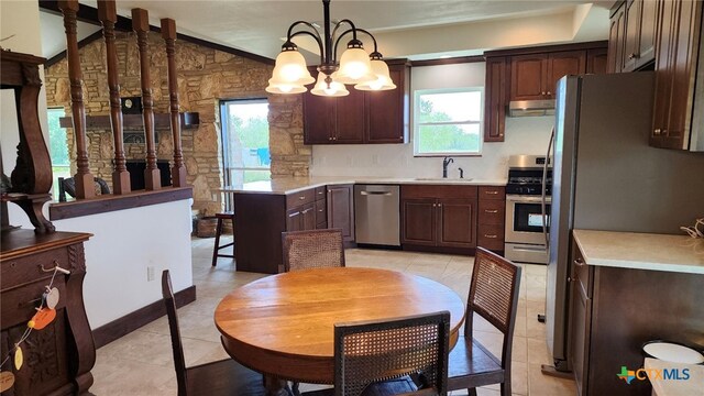 kitchen with light countertops, appliances with stainless steel finishes, under cabinet range hood, and dark brown cabinets