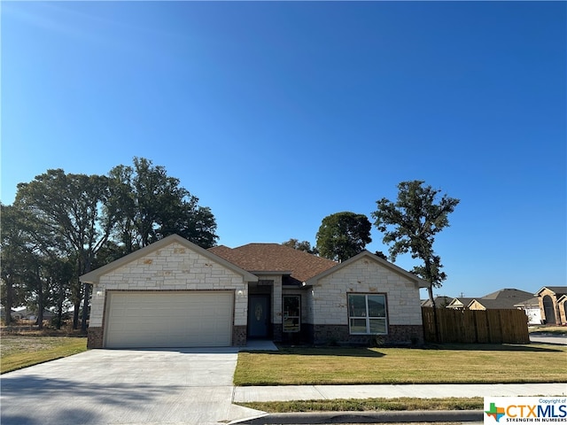 single story home featuring a garage and a front yard