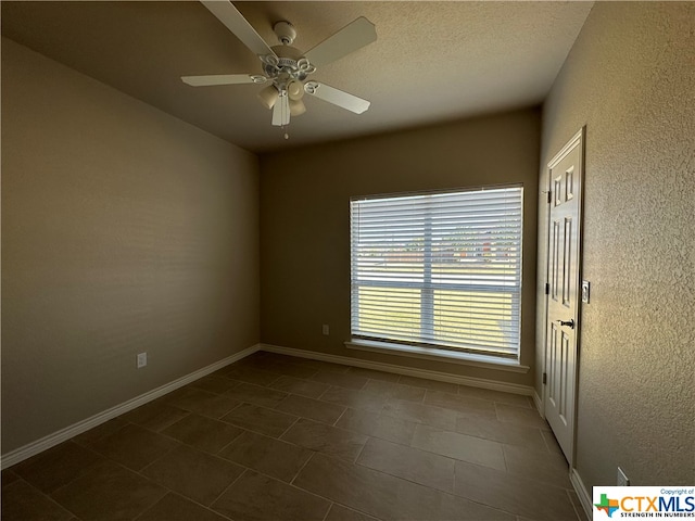 tiled empty room featuring ceiling fan