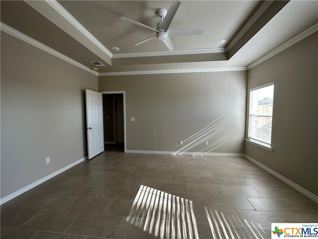 tiled empty room featuring ceiling fan, crown molding, and a tray ceiling