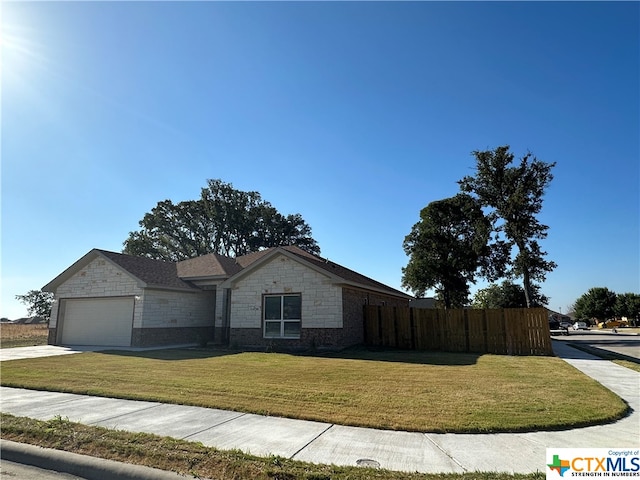 ranch-style home featuring a front lawn and a garage