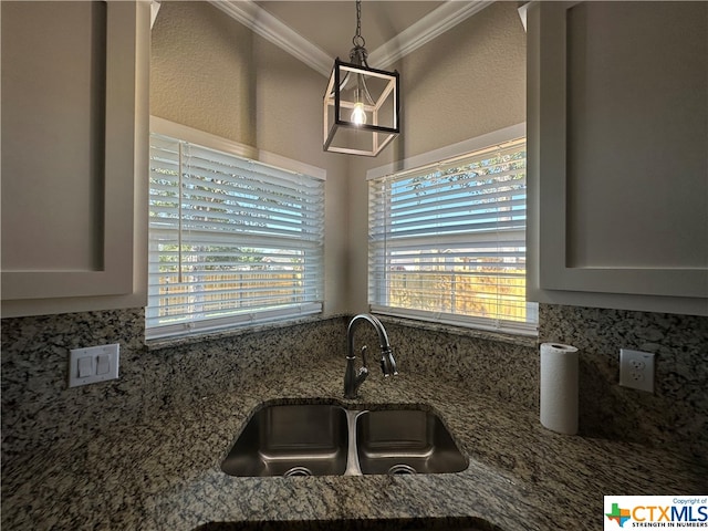 kitchen with decorative light fixtures, sink, a healthy amount of sunlight, and ornamental molding