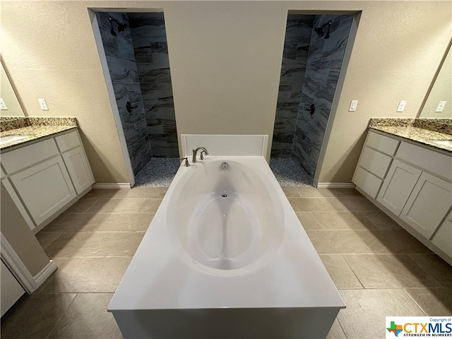 bathroom featuring shower with separate bathtub, vanity, and tile patterned floors