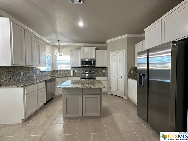 kitchen with a kitchen island, hanging light fixtures, decorative backsplash, and stainless steel appliances