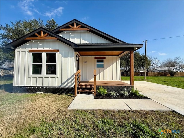 view of front facade with a porch, board and batten siding, and a front yard