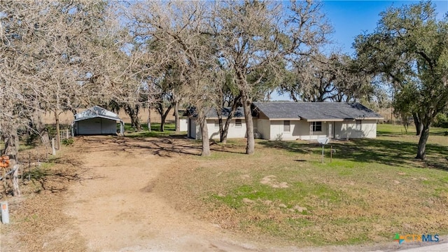 view of front facade featuring a carport and a front lawn