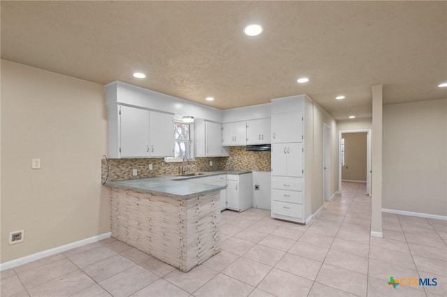 kitchen featuring white cabinetry, sink, decorative backsplash, and kitchen peninsula