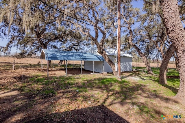 view of yard featuring a carport and a rural view