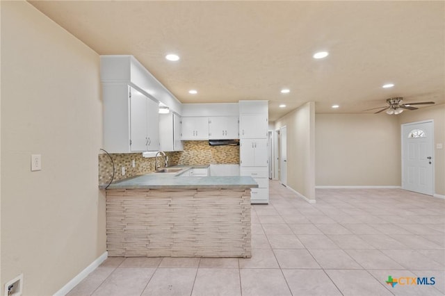 kitchen with sink, ceiling fan, tasteful backsplash, white cabinets, and kitchen peninsula