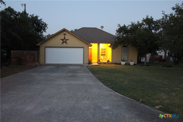 ranch-style home with a garage, concrete driveway, a front yard, and fence