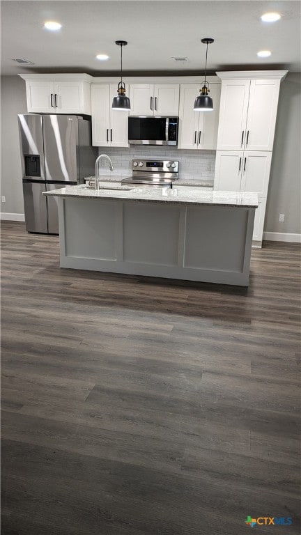 kitchen featuring white cabinetry, appliances with stainless steel finishes, and hanging light fixtures