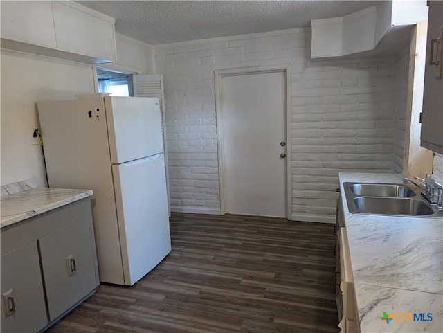 1201 Oblate Dr, Canyon Lake, TX 78133 - kitchen featuring freestanding refrigerator, a sink, dark wood-type flooring, a textured ceiling, and light countertops