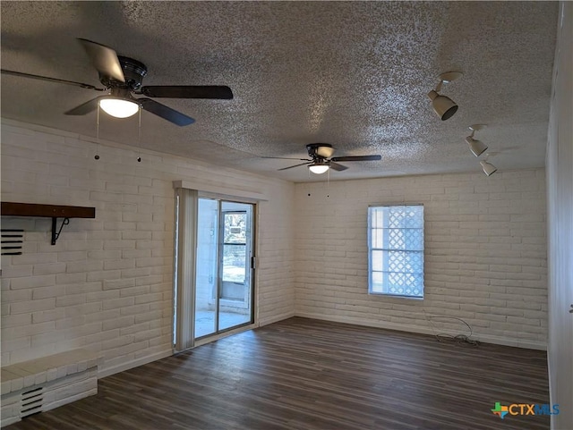 1201 Oblate Dr, Canyon Lake, TX 78133 - spare room with a ceiling fan, brick wall, a textured ceiling, dark wood-style floors, and baseboards