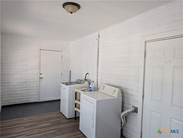 1201 Oblate Dr, Canyon Lake, TX 78133 - laundry area featuring separate washer and dryer, dark wood-style flooring, and brick wall