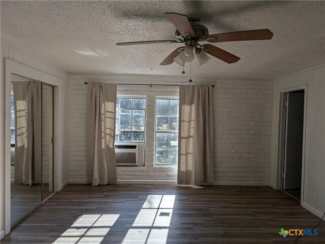 1201 Oblate Dr, Canyon Lake, TX 78133 - spare room with a textured ceiling, wood finished floors, ceiling fan, brick wall, and cooling unit