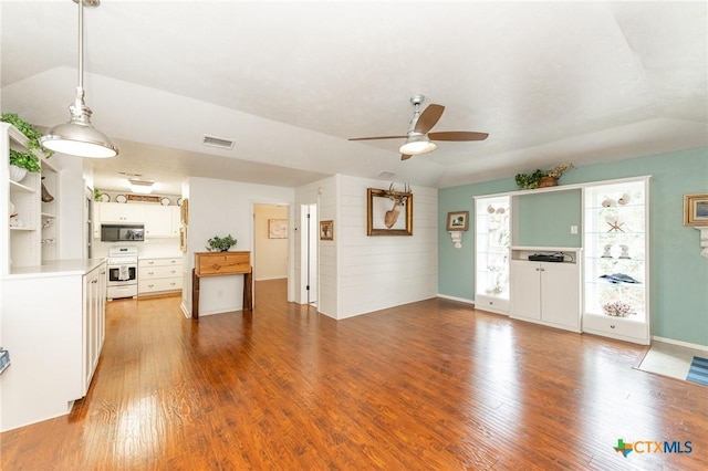 unfurnished living room with light hardwood / wood-style floors, ceiling fan, and wood walls