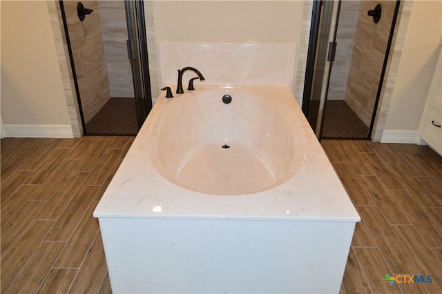 850 County Road 3152, Kempner, TX 76539 - full bath featuring wood finish floors, a shower stall, and a bath
