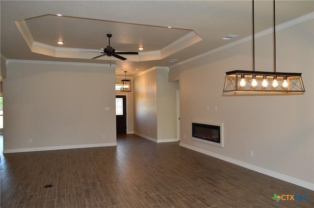850 County Road 3152, Kempner, TX 76539 - unfurnished living room featuring a tray ceiling, dark wood-style flooring, a ceiling fan, a glass covered fireplace, and crown molding