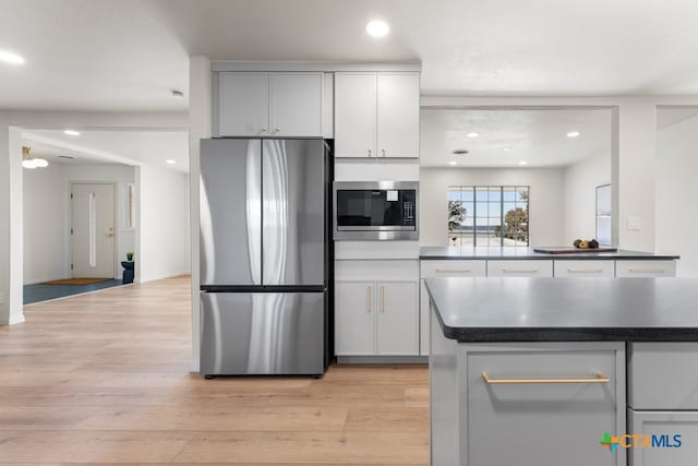 kitchen with white cabinetry, appliances with stainless steel finishes, and light wood-type flooring