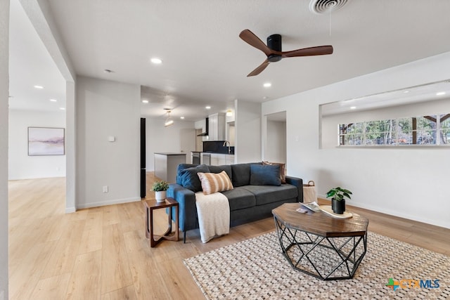 living room with light hardwood / wood-style flooring and ceiling fan