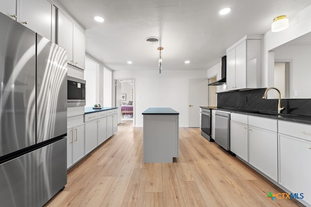 kitchen featuring white cabinetry, sink, backsplash, stainless steel appliances, and light hardwood / wood-style flooring