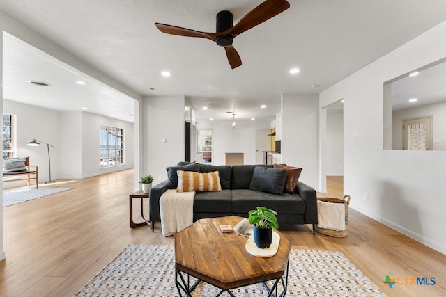 living room featuring light hardwood / wood-style flooring and ceiling fan