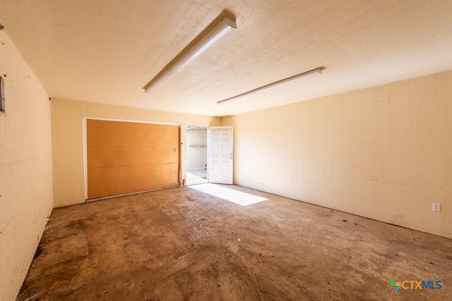 unfurnished bedroom featuring a textured ceiling and concrete flooring